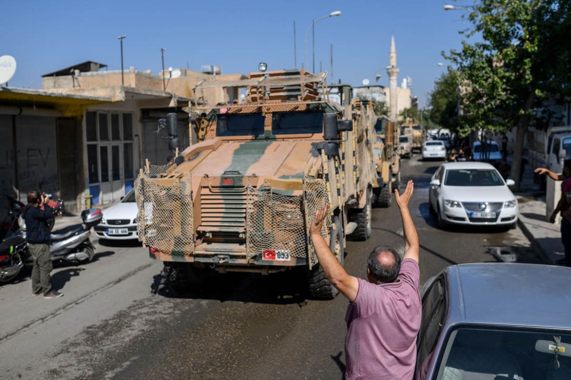 A man waves a Turkish flag as Turkey-backed Syrian opposition fighters going to Tel Abyad from Turkish gate towards Syria in Akcakale in Sanliurfa province on October 10, 2019. Turkey has launched a b