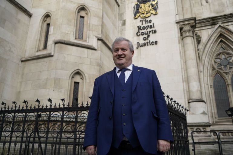 Ian Blackford poses outside the High Court in London - AFP