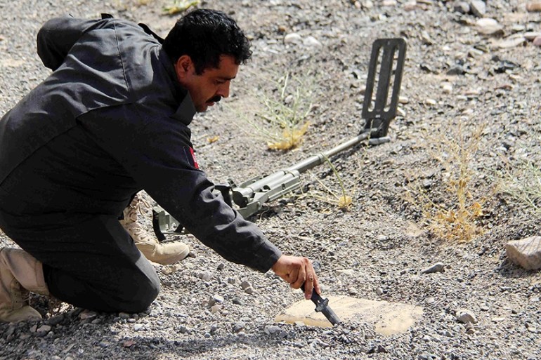 Sirajuddin Afghanmal, an Afghan police official, detects and removes land mines planted by suspected militants in Maiwand district of Kandahar, Afghanistan