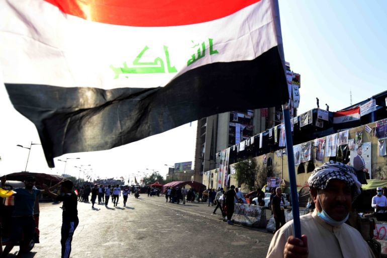 An Iraqi protester carries the Iraqi national flag during a protest at the Al Khilani sqauer in central Baghdad, Iraq, 13 November 2019