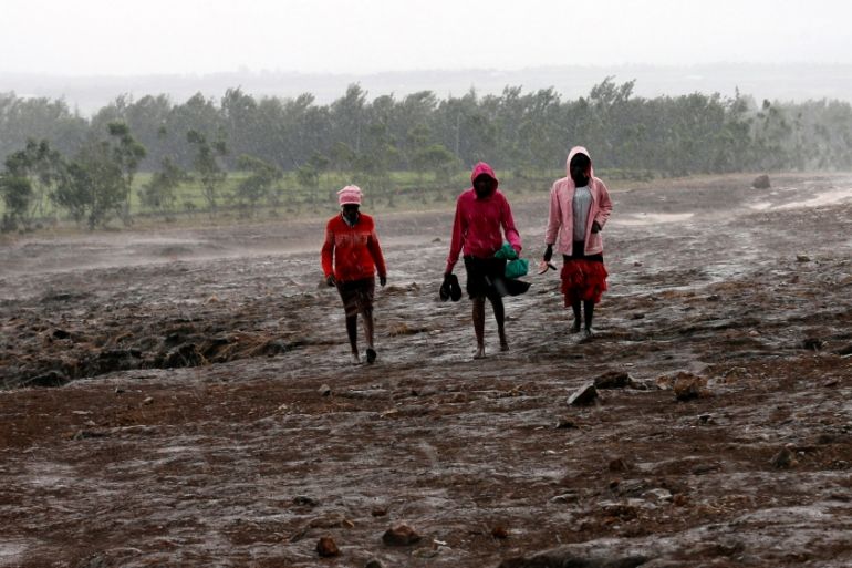 Residents walk in the rain at the Solai farm after their dam burst its walls, overrunning nearby homes, in Solai town near Nakuru