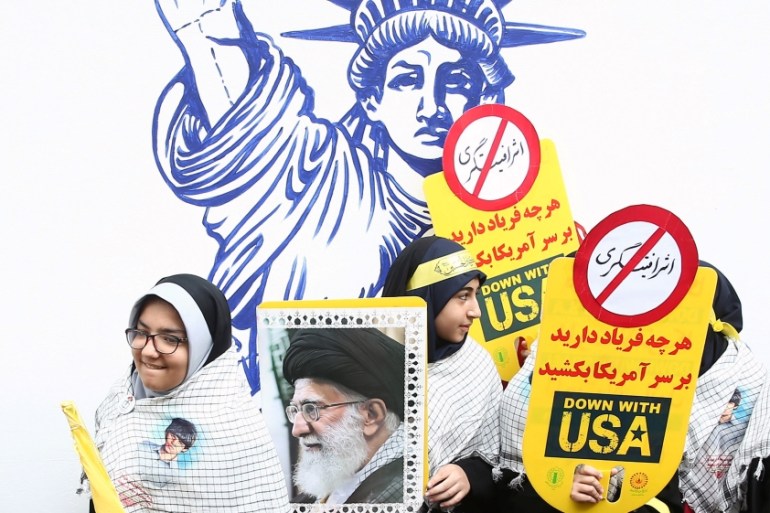 An Iranian protester holds the picture of Iranian Supreme Leader Ayatollah Ali Khamenei as they attend an anti U.S. demonstration