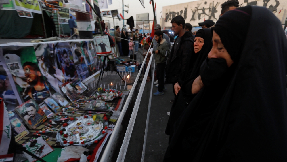 An Iraqi woman reacts as she looks at a makeshift memorial with personal belongings of those who were killed at an anti-government protests at Tahrir Square in Baghdad
