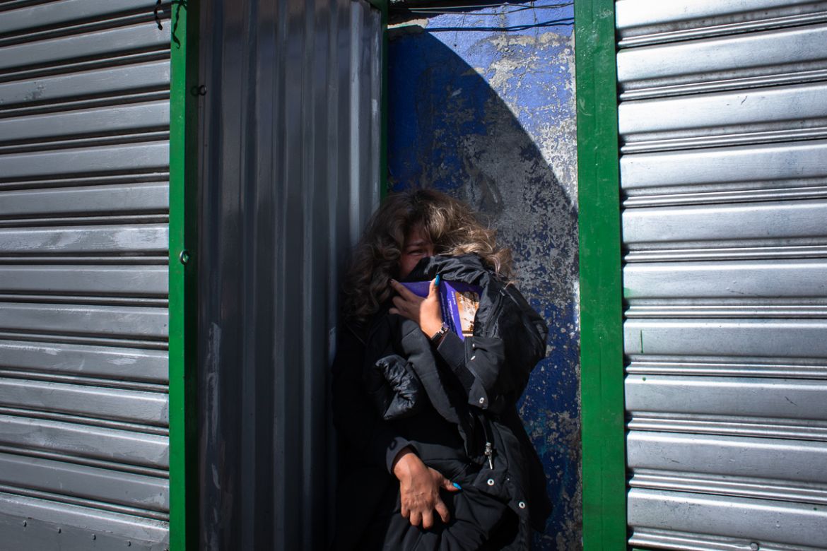 A woman passerby hides from the violence ands tear gas during a demonstration that turned violent in support of the ousted president Evo Morales. La Paz, Bolivia. Nov. 15, 2019 © Erika Pin~eros