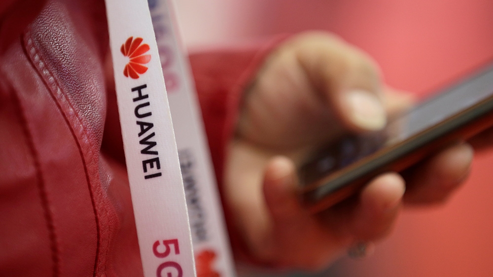 An attendee wears a badge strip with the logo of Huawei and a sign for 5G at the World 5G Exhibition in Beijing, China November 22, 2019