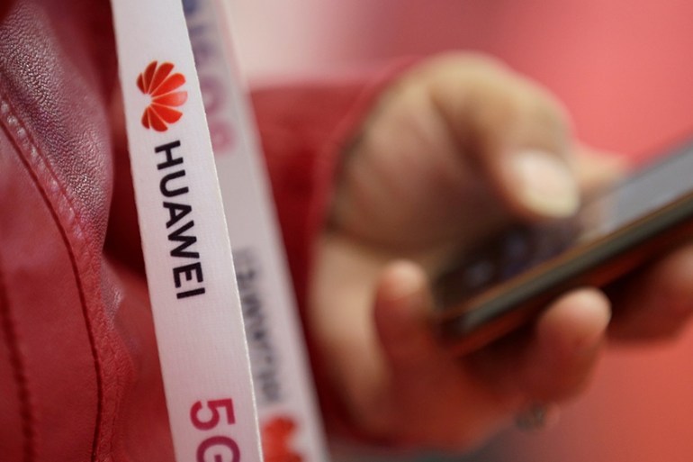An attendee wears a badge strip with the logo of Huawei and a sign for 5G at the World 5G Exhibition in Beijing, China November 22, 2019