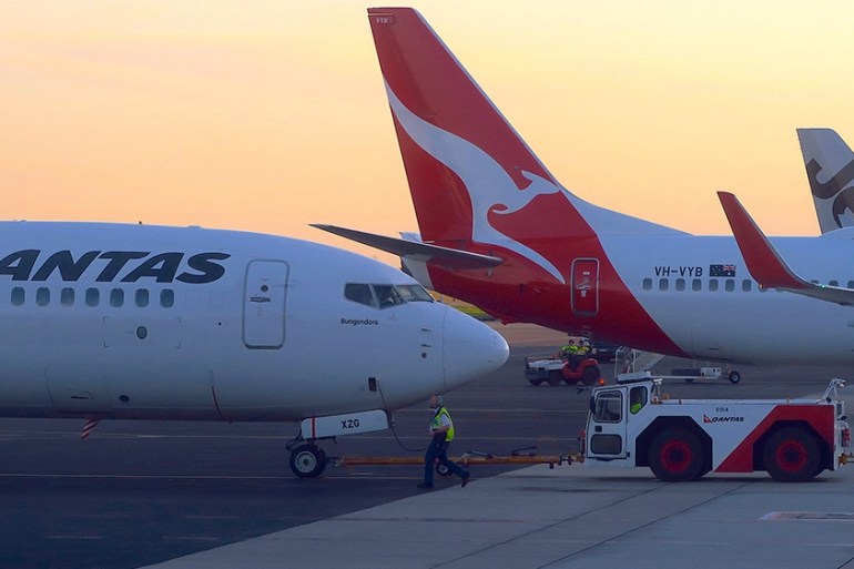 Workers are seen near Qantas Airways, Australia''s national carrier, Boeing 737-800 aircraft on the tarmac at Adelaide Airport, Australia, August 22, 2018