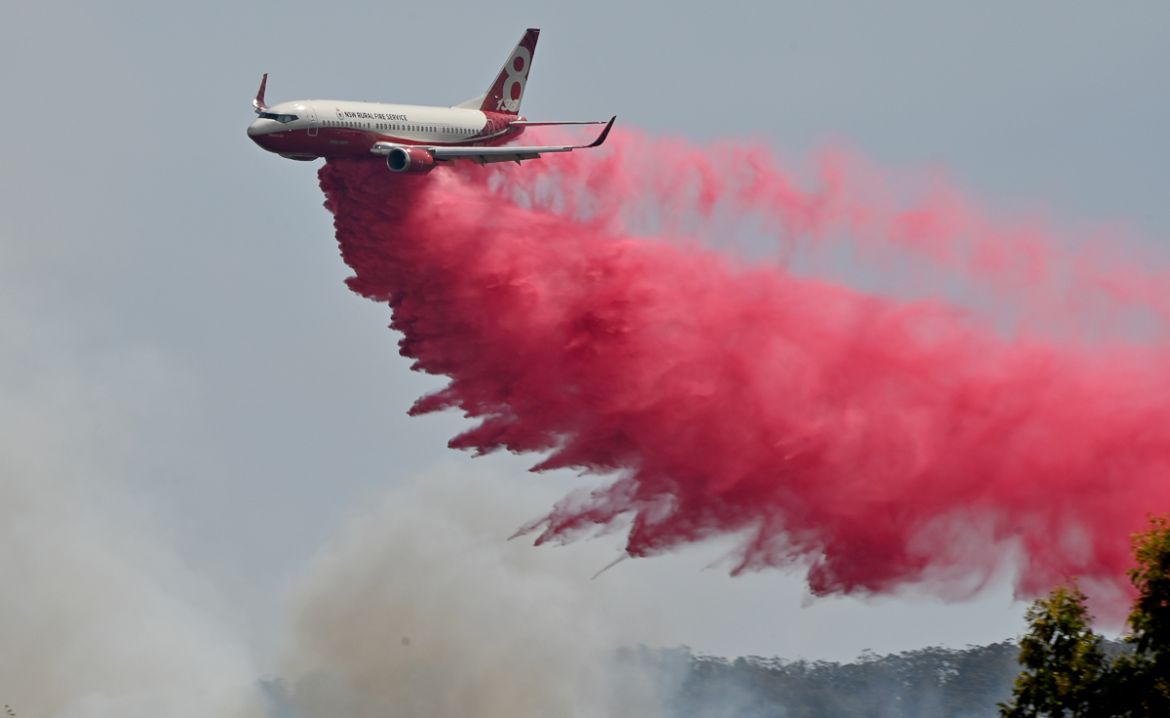 A Rural NSW Fire Service plane drops fire retardent on an out of control bushfire near Taree, 350km north of Sydney on November 12, 2019. - A state of emergency was declared on November 11, 2019 and r