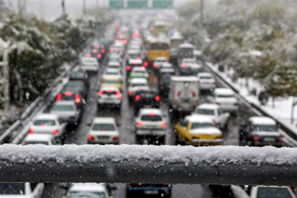 This picture taken on November 16, 2019 shows an elevated view of a congested road in the Iranian capital Tehran amidst heavy snow. - Heavy snowfall blanketed the streets of north Tehran causing traff
