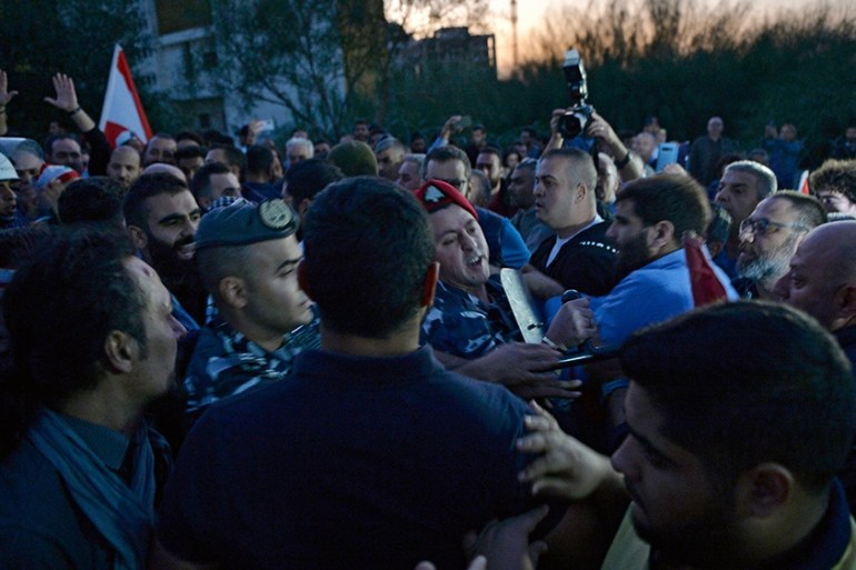 Lebanese Internal Security Forces separate between supporters of the Lebanese President (R) and anti-government protesters (L) at the highway leading to the Presidential palace during a protest to de