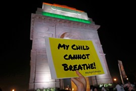A protestor holds a placard in front of the India Gate during a protest against air pollution and climate change in New Delhi, India, November 5, 2019. [Adnan Abidi/Reuters]