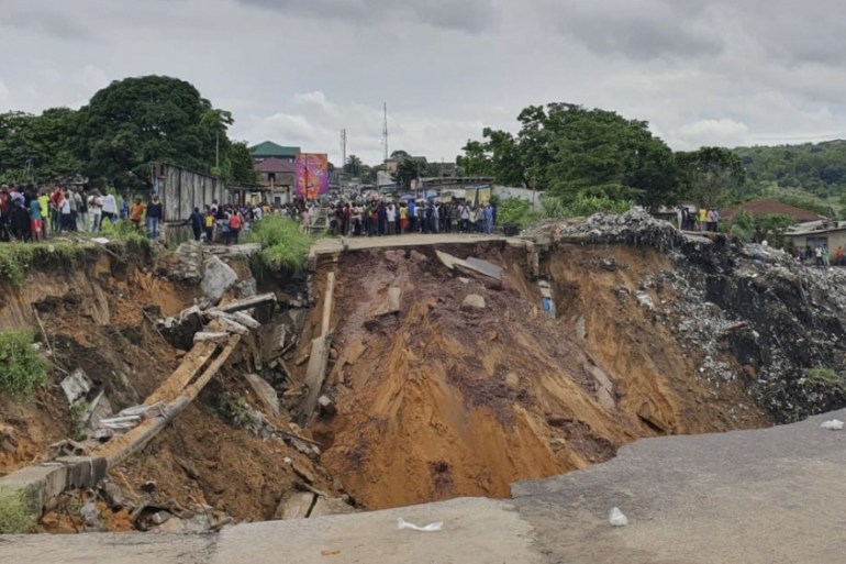A road surface swept away by a landslide caused by torrential overnight rains is photographed in the Lemba district of Kinshasa, on November 26, 2019. Thirty-six people died in the Lemba district of t