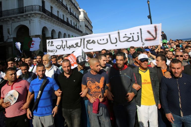 Demonstrators shout slogans and carry national flags during a protest in Algiers