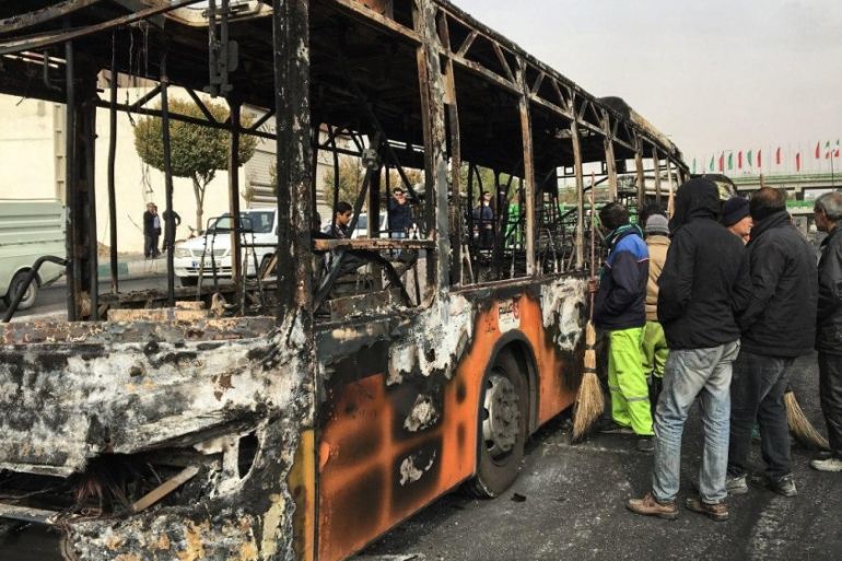 Iranians inspect the wreckage of a bus that was set ablaze by protesters during a demonstration against a rise in gasoline prices in the central city of Isfahan on November 17, 2019. President Hassan