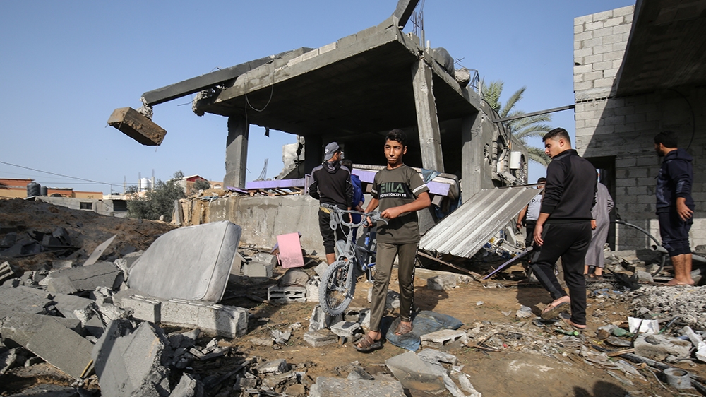Palestinian youths look for salvageable items amid the rubble of a house destroyed in an Israeli air strike in Khan Yunis in the southern Gaza Strip November 13, 2019. - Two Palestinians were killed i
