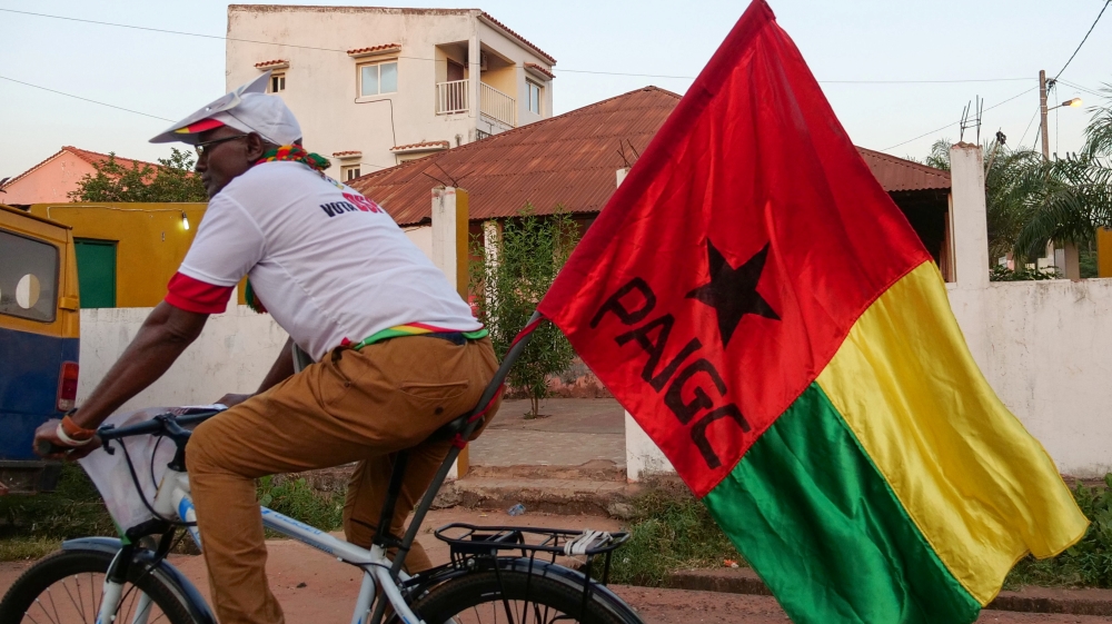A supporter of presidential candidate Domingos Simoes Pereira rides a bicycle in Bissau