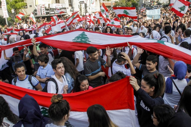 Lebanese students wave national flags and chant slogans as they gather in an anti-government demonstration in the southern city of Sidon on November 6, 2019. Hundreds of schoolchildren led anti-govern