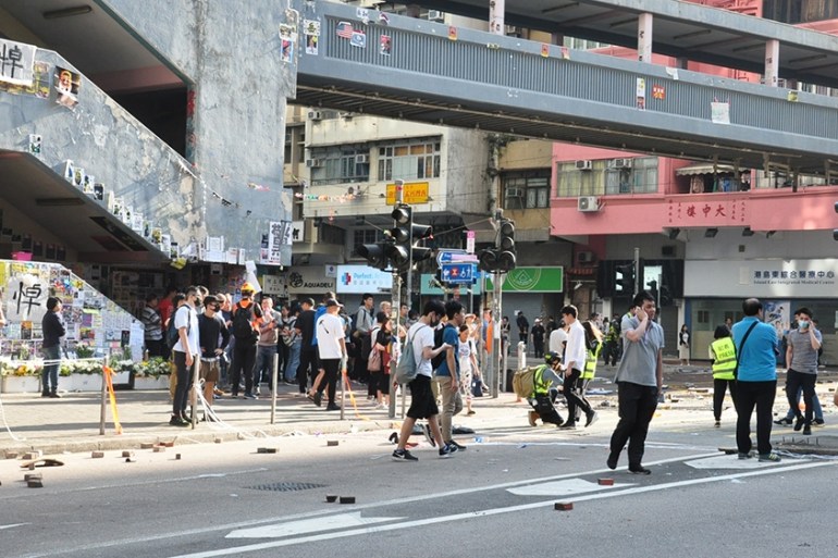 Intersection where the shootings took place, showing Lennon Wall and mourning banner for student dead last week [Violet Law/Al Jazeera]