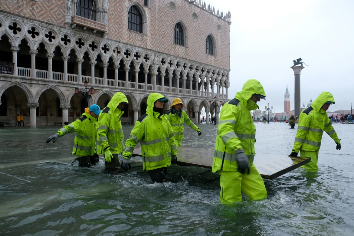 Workers are seen in the flooded St.Mark''s Square during a period of seasonal high water in Venice, Italy November 12, 2019. REUTERS/Manuel Silvestri