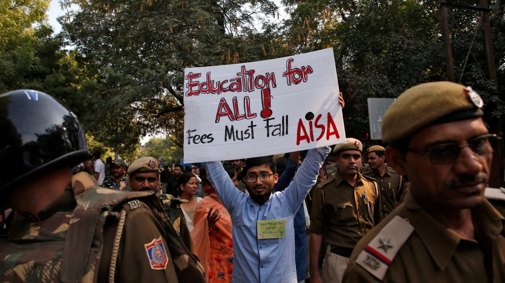 A student of Jawaharlal Nehru University displays a placard during a protest against a proposed fee hike, in New Delhi