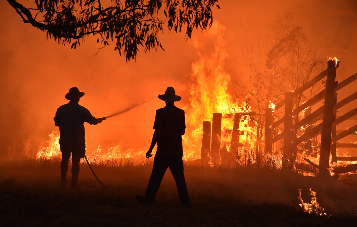 Residents defend a property from a bushfire at Hillsville near Taree, 350km north of Sydney on November 12, 2019. - A state of emergency was declared on November 11 and residents in the Sydney area we