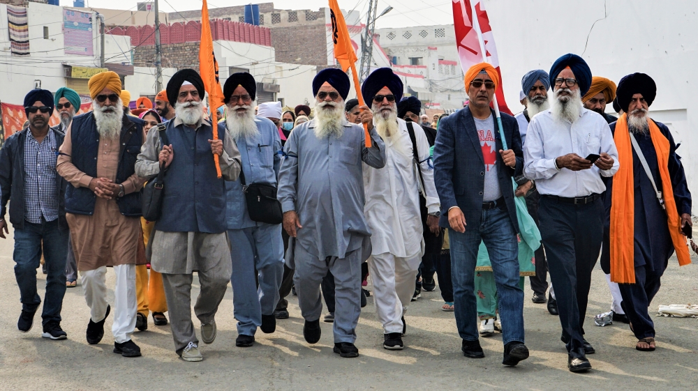 A group of Sikh pilgrims lead the way into the Gurdwara Janam Asthan in Nankana Sahib, Pakistan on the 550th anniversary of Guru Nanak