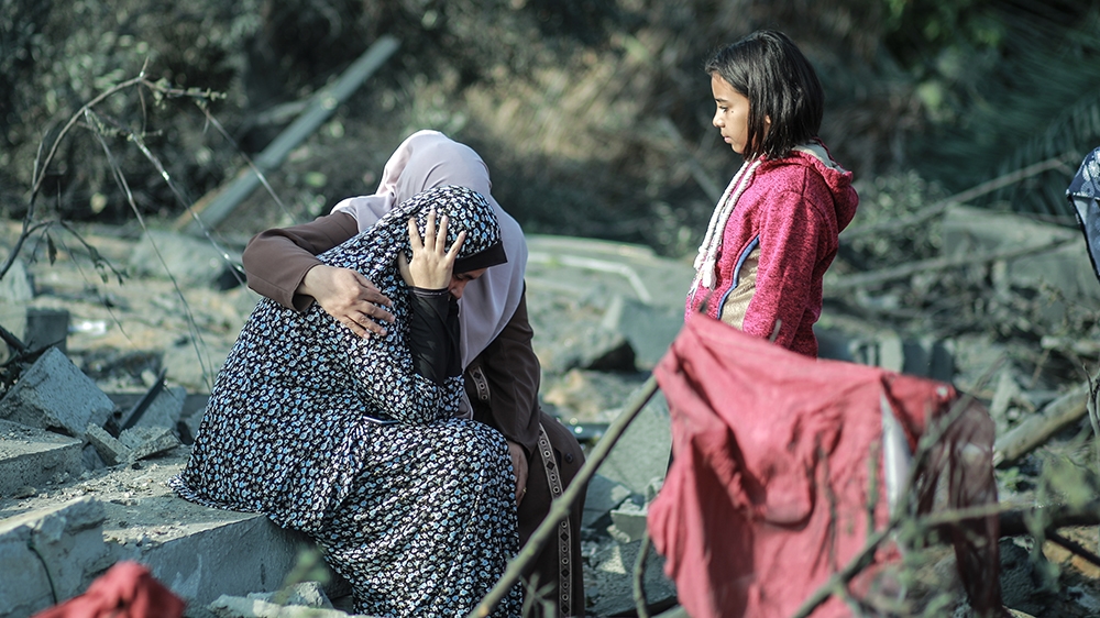 KHAN YUNIS, GAZA - NOVEMBER 13: Palestinian women sit on debris after Israeli airstrikes hit their homes in Khan Yunis, Gaza as tension rises between Israel and Gaza after commander in the Al-Quds Bri