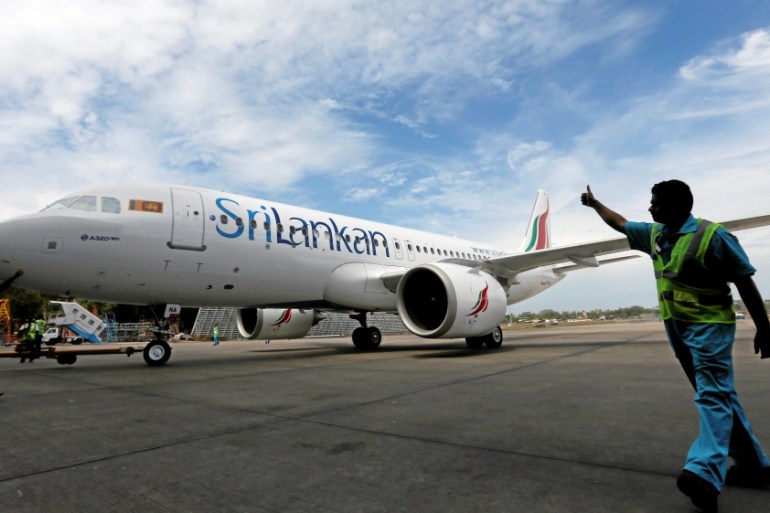 A flight deck director signals to a newly ordered Sri Lankan Airlines A320neo plane at Bandaranaike International Airport in Katunayake