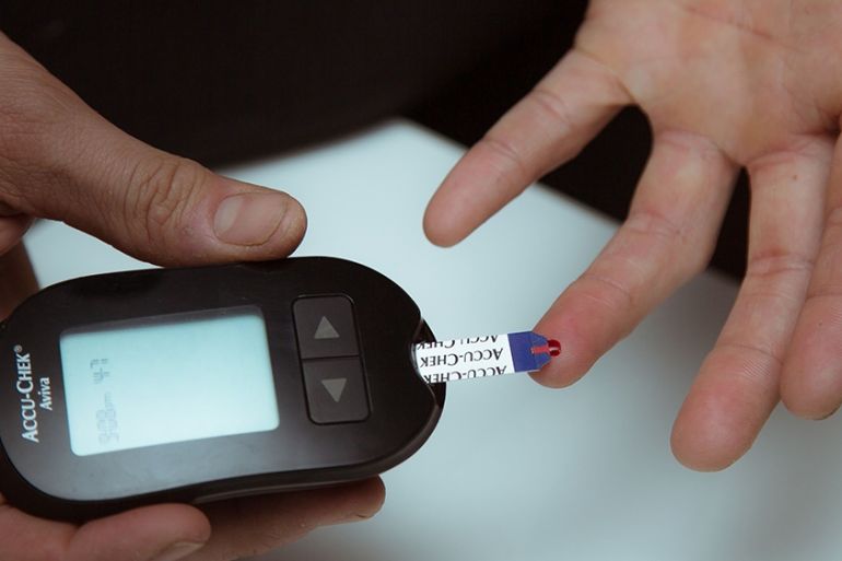 A diabetic person tests blood sugar levels using a Roche Diabetes Care Inc. Accu-Chek brand glucose meter in an arranged photograph taken in the Brooklyn borough of New York, US, April