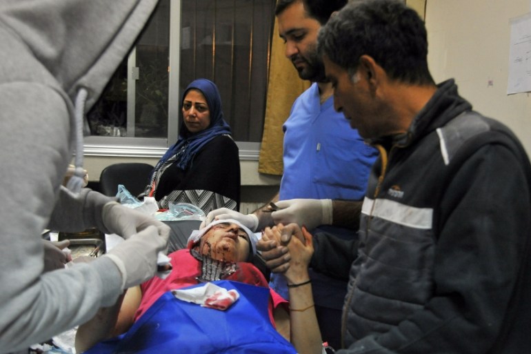 An injured woman receives medical care in Damascus