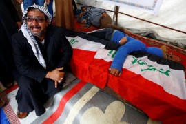 Relatives react by the coffin of a demonstrator who was killed at an anti-government protest overnight in Najaf