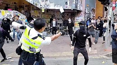 A still image from a social media video shows a police officer aiming his gun at a protester in Sai Wan Ho, Hong Kong, China November 11, 2019.   CUPID PRODUCER via REUTERS 
