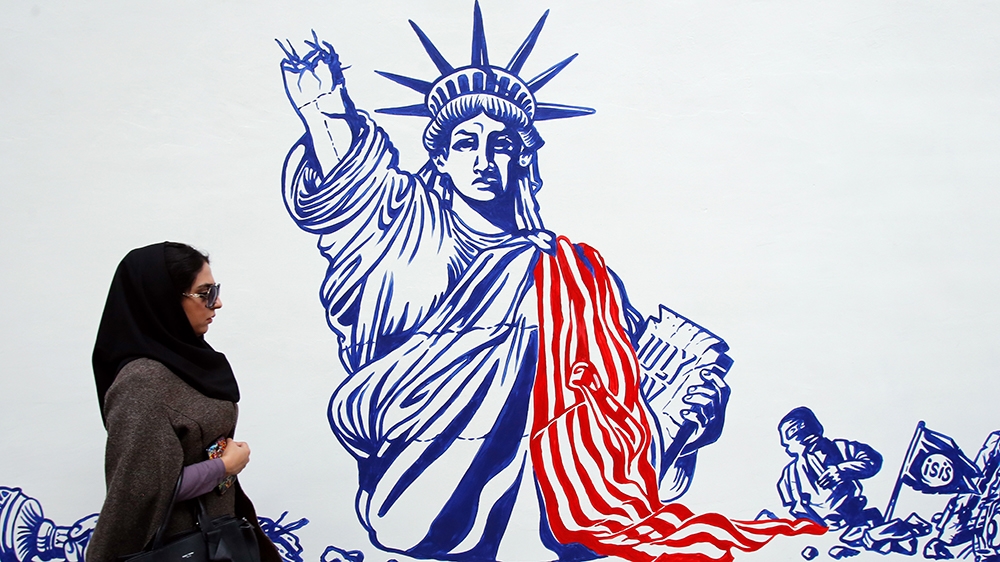 An Iranian woman walks past the new anti-US mural wall painting on the wall of the former US embassy during a ceremony in Tehran, Iran, 02 November 2019. Media reported that Iran unveiled new anti-US 