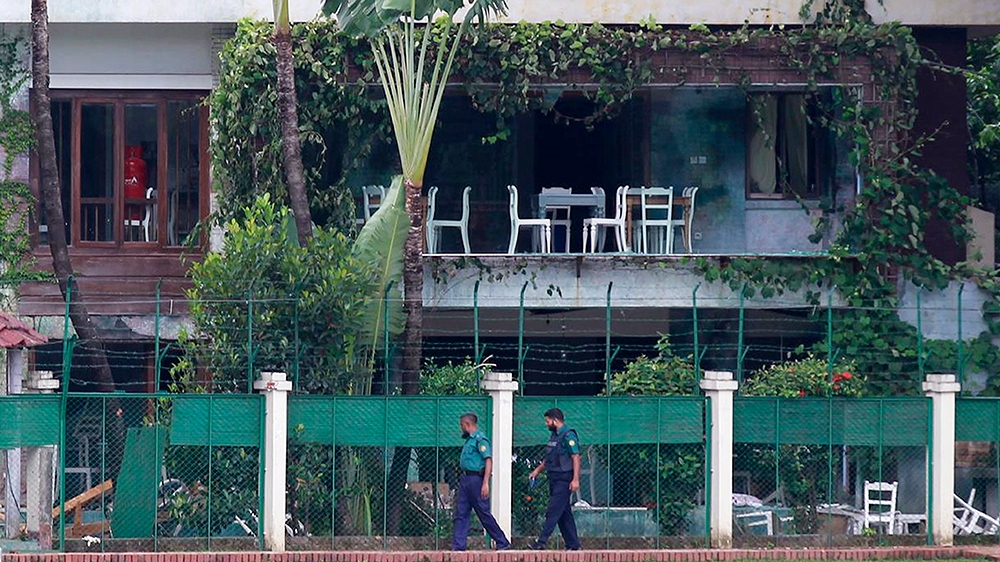 In this July 3, 2016 file photo, Bangladeshi policemen walk past the Holey Artisan Bakery in Dhaka's Gulshan area, Bangladesh, one day after heavily armed militants held dozens of people hostage at th