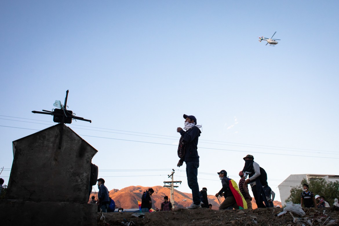 Protesters throw rocks to a helicopter overflying the area and reload during a protest that turned violent in Sacaba. Some 3,000 protesters from the rural regions demanded access to Cochabamba where t