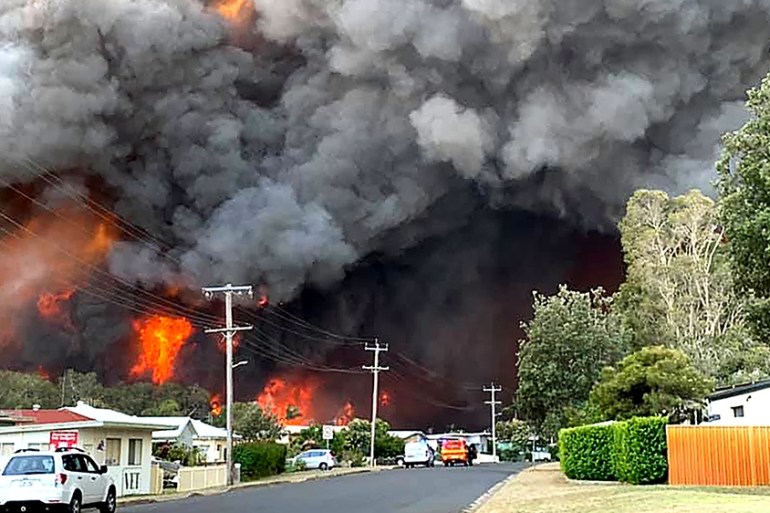 This handout picture taken and received from Kelly-ann Oosterbeek on November 8, 2019 shows flames from an out of control bushfire seen from a nearby residential area in Harrington, some 335 kilometer
