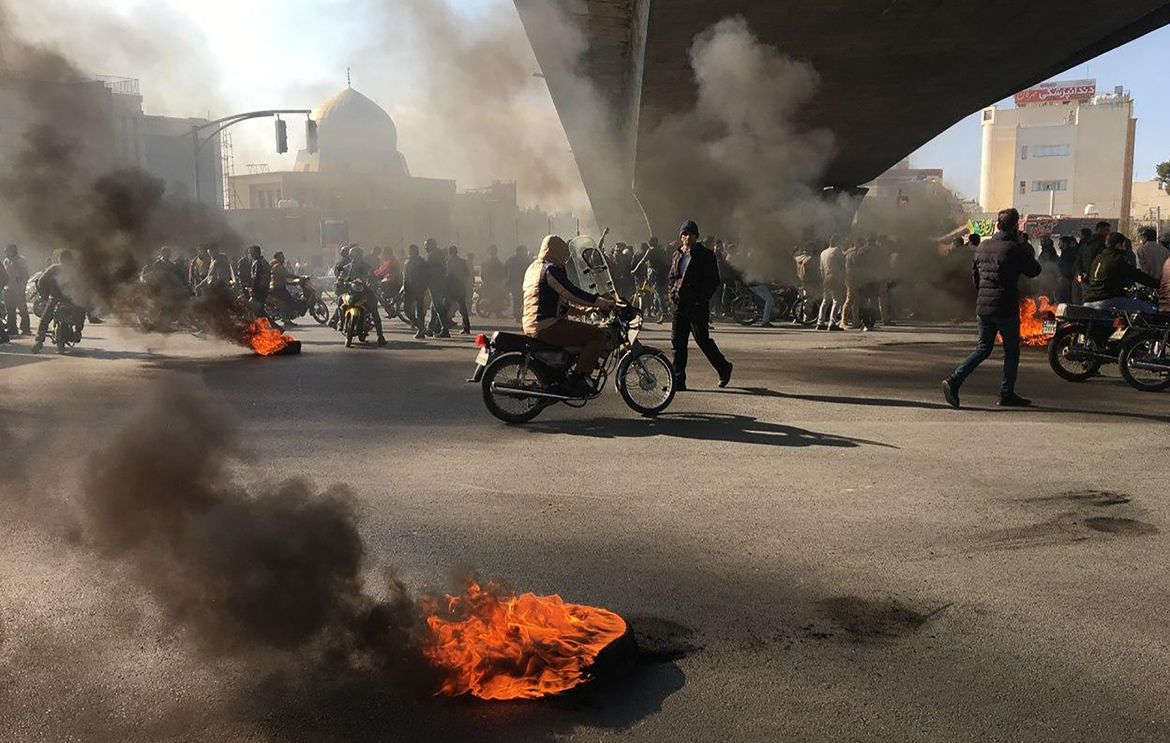 Iranian protesters rally amid burning tires during a demonstration against an increase in gasoline prices, in the central city of Isfahan on November 16, 2019. - One person was killed and others injur