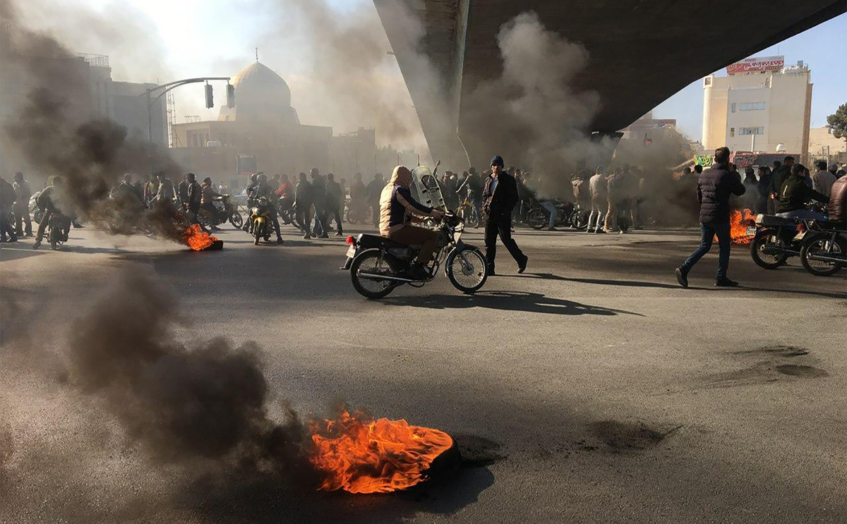 Manifestanti iraniani si radunano tra pneumatici in fiamme durante una manifestazione contro l'aumento dei prezzi della benzina, nella città centrale di Isfahan il 16 novembre 2019. - Una persona è stata uccisa e altre ferite