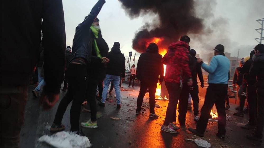 Iranian protesters gather around a fire during a demonstration against an increase in gasoline prices in the capital Tehran, on November 16, 2019. - One person was killed and others injured in protest
