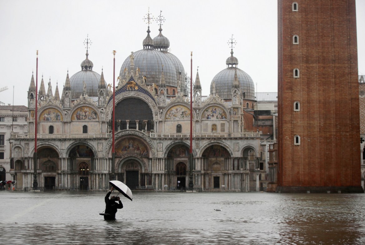 A photographer takes pictures in a flooded St. Mark''s Square, in Venice, Italy, Tuesday, Nov. 12, 2019. The high tide reached a peak of 127cm (4.1ft) at 10:35am while an even higher level of 140cm(4.6