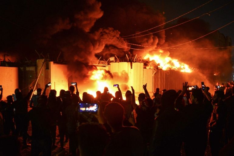 Iraqi demonstrators gather as flames start consuming Iran''s consulate in the southern Iraqi Shiite holy city of Najaf on November 27, 2019, two months into the country''s most serious social crisis in