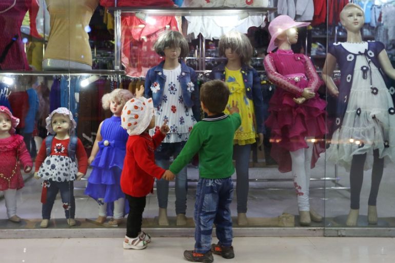 Afghan kids look through a shop window at children''s clothes in Kabul, Afghanistan, Wednesday, April 6, 2016. (AP Photo/Rahmat Gul)