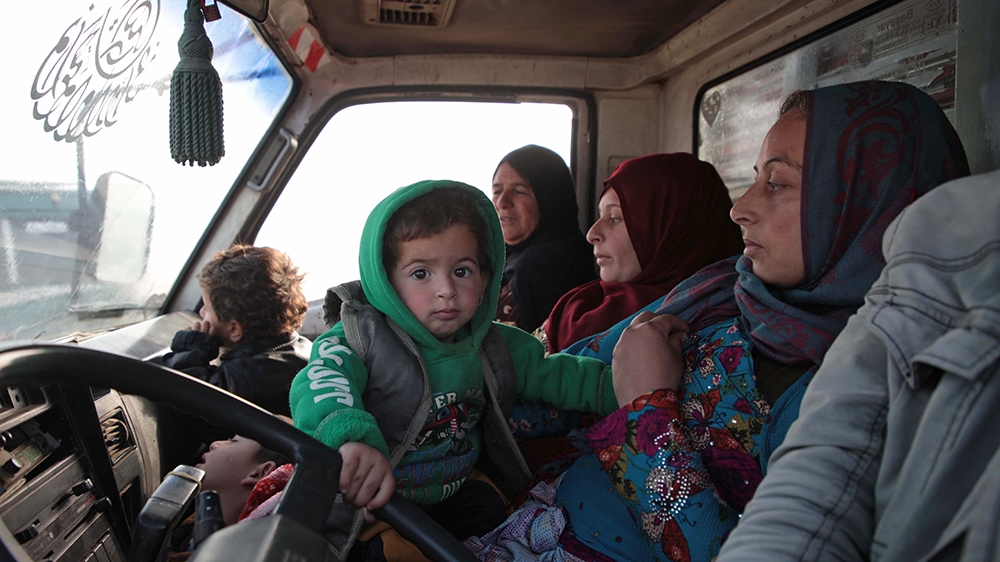 Syrians sit in a vehicle as they drive towards the northern areas of Syria's Idlib province near the Syrian-Turkish border as they flee the bombardments in the southern areas of the country's last maj