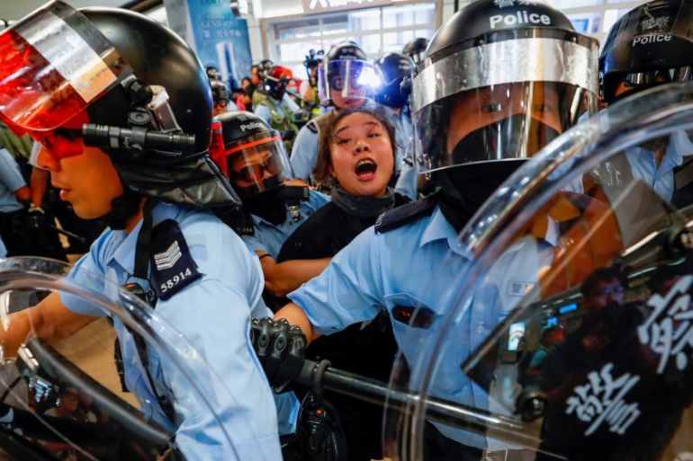 Riot police detain a woman in the midst of the pro-democracy protests in Hong Kong