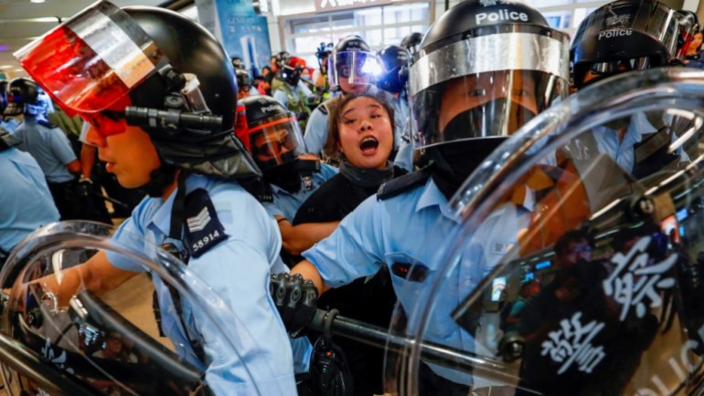 La police anti-émeute arrête une femme au milieu des manifestations pro-démocratie à Hong Kong