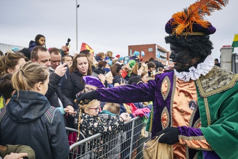 A sooty-faced Zwarte Pieten, or Black Pete, hands out treats during the arrival of Dutch Saint Nicholas, or Sinterklaas, in Scheveningen, Netherlands on November 16, 2019. The ''Black Petes'', people