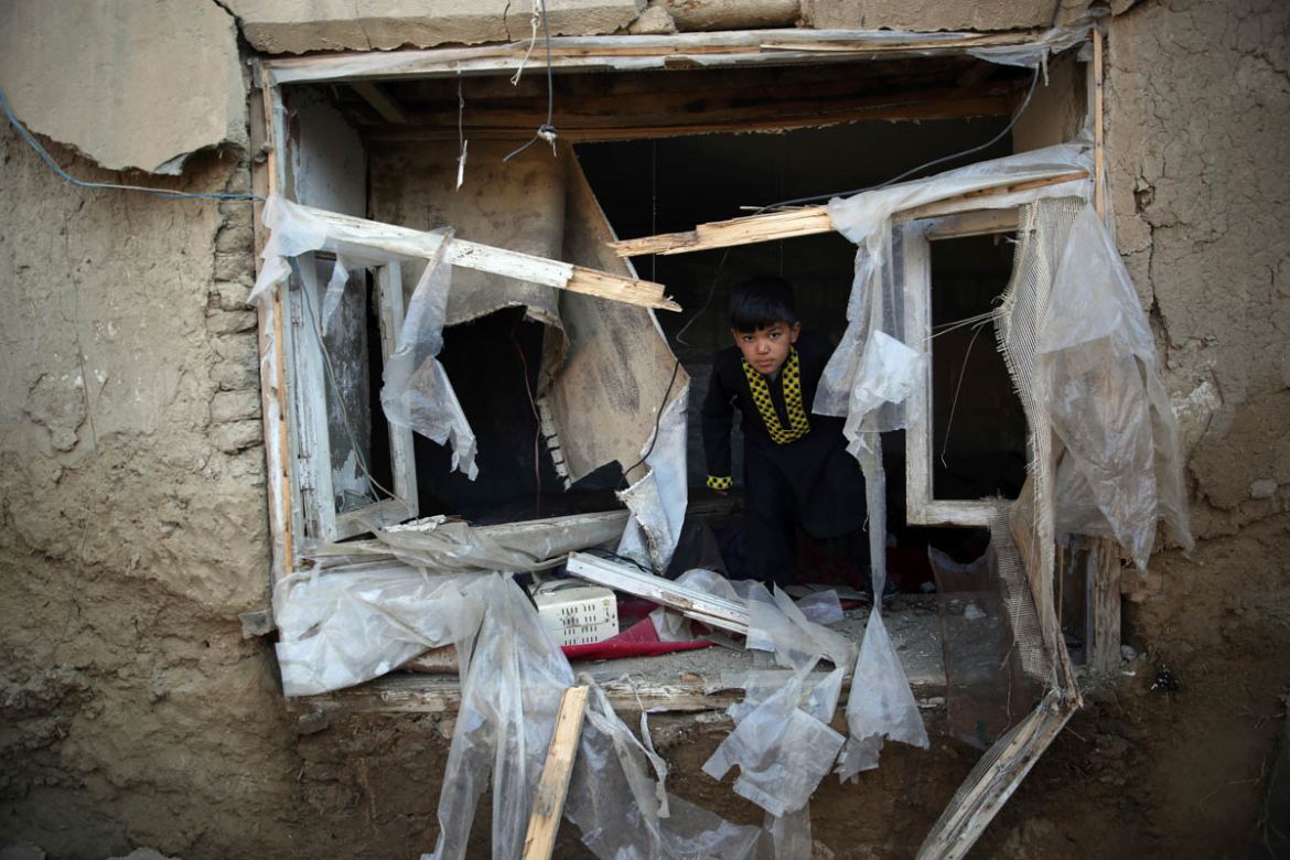 A boy inspects his damaged home after after an attack near the Bagram Air Base in Parwan province of Kabul, Afghanistan, Wednesday, Dec. 11, 2019. A powerful suicide bombing Wednesday targeted an unde