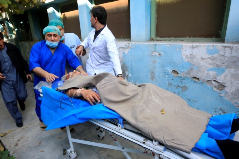 Hospital workers carry Japanese doctor Tetsu Nakamura to a hospital after an attack in Jalalabad