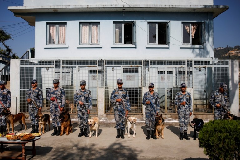 Members of Nepal''s Armed Police Force stand with their dogs before worshipping them during the dog festival as part of Tihar celebrations in Kathmandu