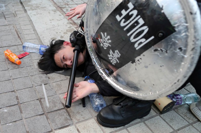 La police arrête un manifestant de Hong Kong après qu'un drapeau chinois a été retiré d'un mât lors d'une manifestation en faveur des droits humains des Ouïghours du Xinjiang à Hong Kong, Chine, le 22 décembre 2019. REUTERS/Lucy Nicho